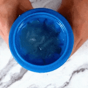 Hand holding the blue Slushy Cup showing the frozen inner lining that turns any drink to slush