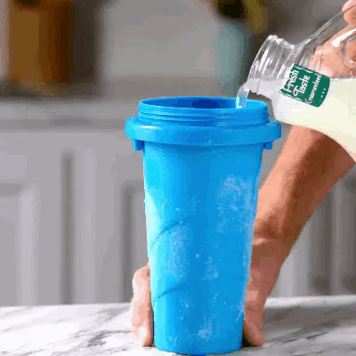 Pouring a drink into the blue Slushy Cup to make a homemade slushie in about a minute